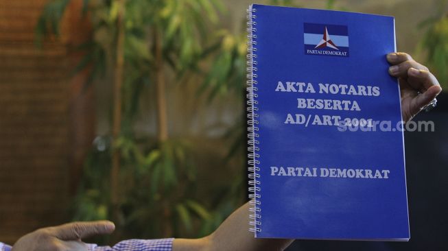 Salah satu penggagas kongres luar biasa (KLB) Partai Demokrat Deli Serdang menunjukkan akta notaris beserta AD/ART partai tahun 2001 sebelum memberikan keterangan kepada wartawan di salah satu restoran di Kawasan Kuningan, Jakarta, Selasa (9/3/2021). [Suara.com/Angga Budhiyanto]