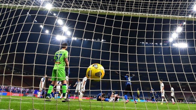 Bek Inter Milan, Milan Skriniar menembak bola dan mencetak gol selama pertandingan sepak bola Serie A Italia Inter Milan melawan Atalanta di Giuseppe-Meazza, Selasa (9/3/2021) dini hari WIB. Miguel MEDINA / AFP