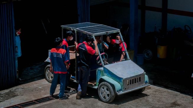 Pelajar melakukan uji coba mengisi daya baterai mobil melalui panel surya di SMKN 4 Pandeglang, Banten, Selasa (9/3/2021). ANTARA FOTO/Muhammad Bagus Khoirunas