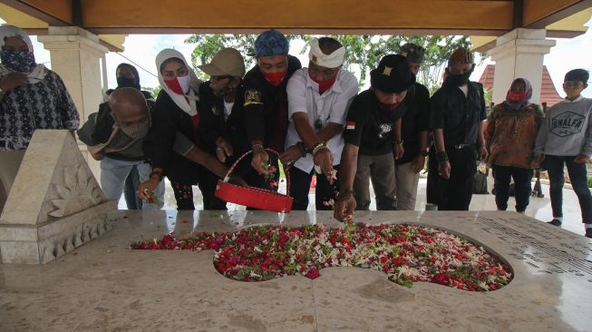 Warga menabur bunga di makam WR Soepratman di Surabaya, Jawa Timur, Selasa (9/3/2021). ANTARA FOTO/Didik Suharton