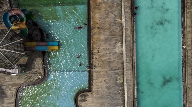 Foto udara pengunjung berenang di Kolam Renang Tirta Winarya, Sindangrasa, Kabuapten Ciamis, Jawa Barat, Rabu (10/3/2021). . ANTARA FOTO/Adeng Bustomi
