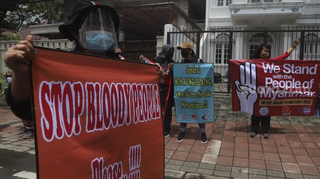 Massa yang tergabung dalam Konfederasi Serikat Buruh Seluruh Indonesia (KSBSI) membentangkan spanduk saat melakukan aksi solidaritas di depan Kedutaan Besar Myanmar, Jakarta, Rabu (10/3/2021). [Suara.com/Angga Budhiyanto]