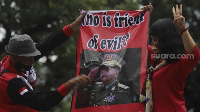 Sejumlah massa yang tergabung dalam Konfederasi Serikat Buruh Seluruh Indonesia (KSBSI) merusak poster bergambar Jendral Tentara Myanmar, Min Aung Hlaing saat melakukan aksi solidaritas di depan Kedutaan Besar Myanmar, Jakarta, Rabu (10/3/2021). [Suara.com/Angga Budhiyanto]