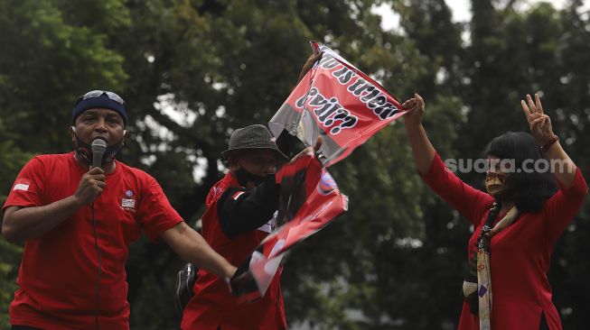 Sejumlah massa yang tergabung dalam Konfederasi Serikat Buruh Seluruh Indonesia (KSBSI) merusak poster bergambar Jendral Tentara Myanmar, Min Aung Hlaing saat melakukan aksi solidaritas di depan Kedutaan Besar Myanmar, Jakarta, Rabu (10/3/2021). [Suara.com/Angga Budhiyanto]