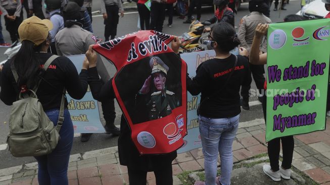 Massa yang tergabung dalam Konfederasi Serikat Buruh Seluruh Indonesia (KSBSI) membawa spanduk saat melakukan aksi solidaritas di depan Kedutaan Besar Myanmar, Jakarta, Rabu (10/3/2021). [Suara.com/Angga Budhiyanto]