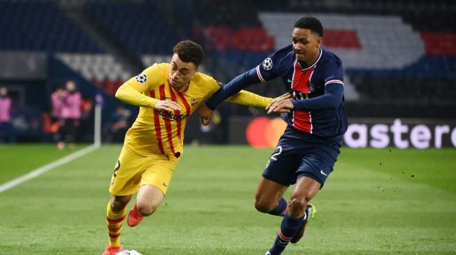 Bek Barcelona Sergino Dest (kiri) memperebutkan bola dengan bek Paris Saint-Germain (PSG) Abdou Diallo dalam pertandingan leg kedua babak 16 besar Liga Champions (PSG vs Barcelona) di Parc des Princes, Paris, Kamis (11/3/2021) dini hari WIB. [FRANCK FIFE / AFP].