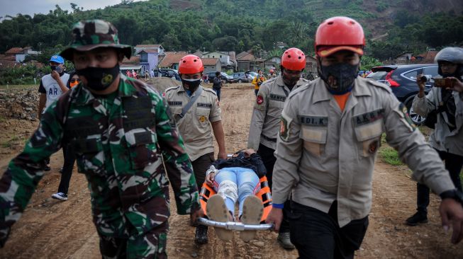 Petugas TNI dan Polri membawa korban bencana saat mengikuti simulasi tanggap bencana di Batujajar, Kabupaten Bandung Barat, Jawa Barat, Jumat (12/3/2021). ANTARA FOTO/Raisan Al Farisi
