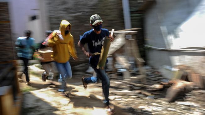 Warga berlari menuju tempat yang aman saat mengikuti simulasi tanggap bencana di Batujajar, Kabupaten Bandung Barat, Jawa Barat, Jumat (12/3/2021).  ANTARA FOTO/Raisan Al Farisi