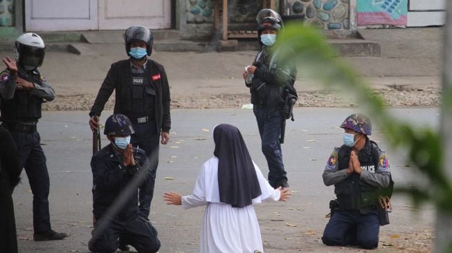 Suster Ann Roza Nu Tawng, seorang biarawati di Myitkyina, Myanmar, berlutut di hadapan sejumlah aparat yang juga ikut berlutut di Myitkyina, Myanmar, pada Senin, 8 Maret 2021. [Foto/AFP]
