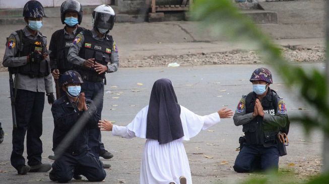 Suster Ann Roza Nu Tawng, seorang biarawati di Myitkyina, Myanmar, berlutut di hadapan sejumlah aparat yang juga ikut berlutut di Myitkyina, Myanmar, pada Senin, 8 Maret 2021. [Foto/AFP]
