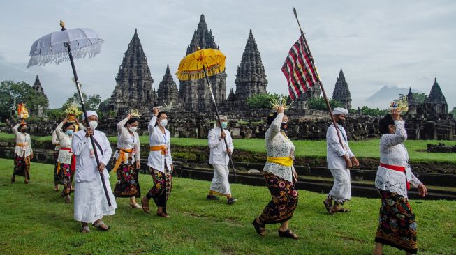 Umat Hindu berjalan menuju candi saat upacara Tawur Agung Kesanga di Candi Prambanan, Sleman, DI Yogyakarta, Sabtu (13/3/2021). ANTARA FOTO/Hendra Nurdiyansyah
