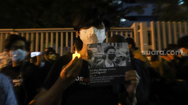 Massa menunjukkan foto wajah para korban kudetan militer Myanmar saag aksi solidaritas untuk Myanmar di depan Gedung ASEAN, Jakarta Selatan, Jumat (12/2/2021). [Suara.com/Alfian Winanto]