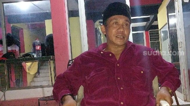 Asep anak dari pemilik rumah almarhum Munir yang akses kediaman keluarganya dipagar beton setinggi dua meter saat ditemui, Jumat (12/3/2021) malam. [Suara.com/Muhammad Jehan Nurhakim]