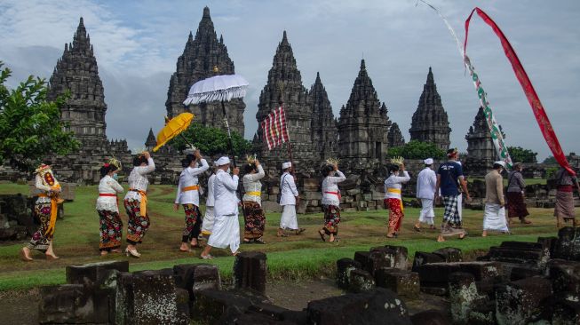 Umat Hindu berjalan menuju candi saat upacara Tawur Agung Kesanga di Candi Prambanan, Sleman, DI Yogyakarta, Sabtu (13/3/2021). ANTARA FOTO/Hendra Nurdiyansyah
