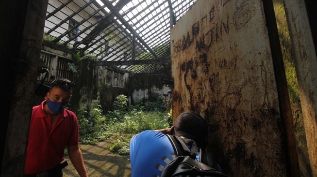 Warga berjalan di salah satu bangunan di bekas Penjara Kalisosok di Surabaya, Jawa Timur, Jumat (12/3/2021). ANTARA FOTO/Didik Suhartono