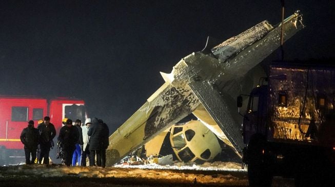 Penyelidik bekerja di lokasi jatuhnya pesawat Antonov An-26 di Bandara Almaty, Kazakhstan, pada (13/3/2021). [Abduaziz MADYAROV / AFP]