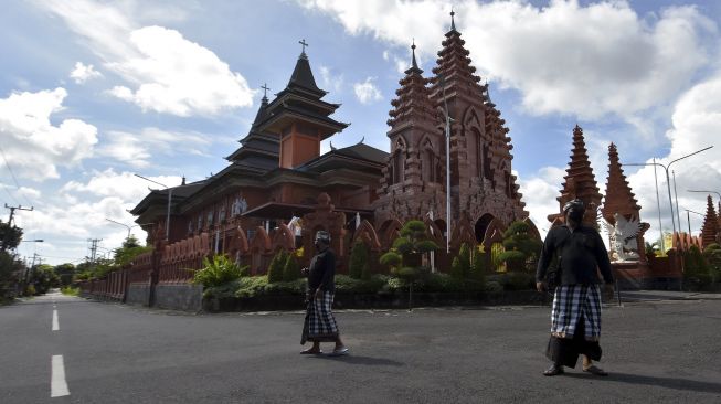 Pecalang atau petugas pengamanan adat Bali memantau situasi di dekat Gereja Katolik Roh Kudus Katedral saat Hari Raya Nyepi Tahun Saka 1943 di wilayah Desa Sumerta Kelod, Denpasar, Bali, Minggu (14/3/2021). [ANTARA FOTO/Nyoman Hendra Wibowo]