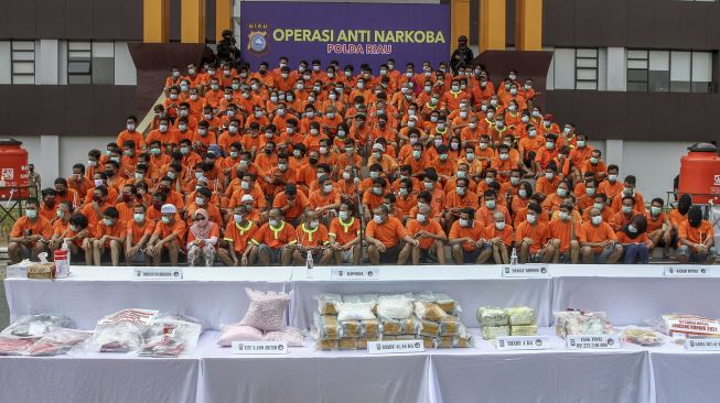 Ratusan orang tersangka penyalahguna, kurir dan bandar narkoba dihadirkan ketika rilis hasil operasi narkoba di Mapolda Riau, Pekanbaru, Riau, Minggu (14/3/2021). [ANTARA FOTO/Rony Muharrman]