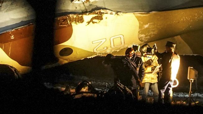 Penyelidik bekerja di lokasi jatuhnya pesawat Antonov An-26 di Bandara Almaty, Kazakhstan, pada (13/3/2021). [Abduaziz MADYAROV / AFP]