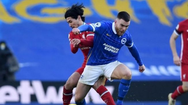 Pemain Brighton, Aaron Connolly, saat berduel dengan Takumi Minamino. (NEIL HALL / POOL / AFP)