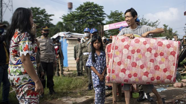 Warga memindahkan barang miliknya saat penertiban bangunan liar di Jln Gub Hasan Bastari Jakabaring, Palembang, Senin (15/3/2021). [ANTARA FOTO/Nova Wahyudi]