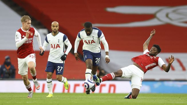 Gelandang Arsenal Thomas Partey (kanan) menangani gelandang Tottenham Hotspur Tanguy Ndombele (tengah) selama pertandingan sepak bola Liga Inggris antara Arsenal dan Tottenham Hotspur di Emirates Stadium, London, pada (14/3/2021). [Julian Finney / POOL / AFP]