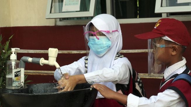 Siswa SD mencuci tangan sebelum masuk kelas saat uji coba pembelajaran tatap muka di SDN Tegalwaru 02, Ciampea, Kabupaten Bogor, Jawa Barat, Senin (15/3/2021). [ANTARA FOTO/YArif Firmansyah]