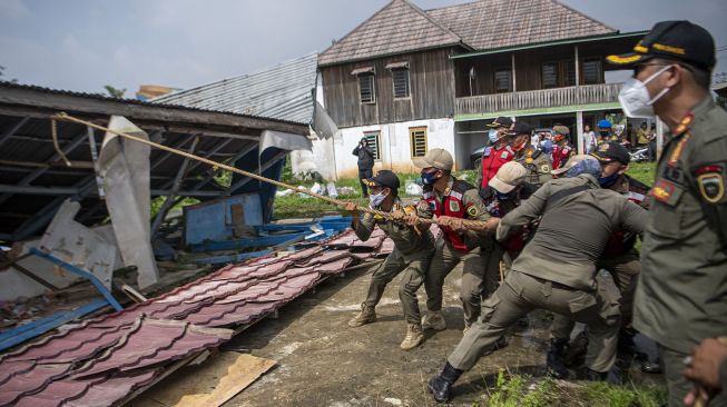 Sejumlah Anggota Sat Pol PP Provinsi Sumatera Selatan membongkar bangunan liar yang berada di Jln Gub Hasan Bastari Jakabaring, Palembang, Senin (15/3/2021). [ANTARA FOTO/Nova Wahyudi]