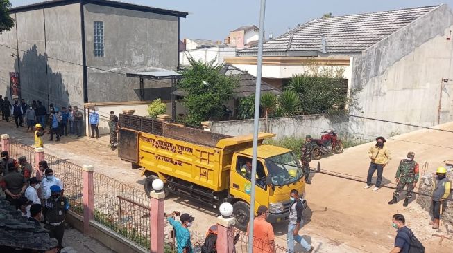 Aparat mengamankan pembongkaran tembok beton di Jalan Akasia Ciledug (Suara.com/Jehan)