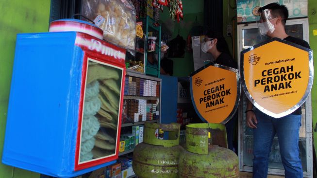 Dua relawan melakukan edukasi tentang bahaya merokok kepada pedagang saat kampanye "Cegah Perokok Anak" di Peta Barat Cengkareng, Jakarta, Rabu (17/3/2021). ANTARA FOTO/Muhammad Iqbal