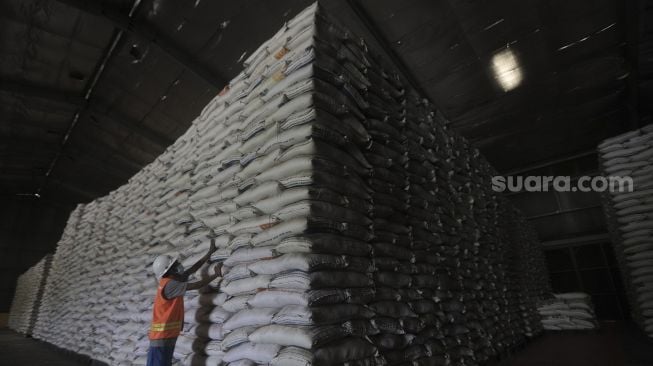 Pekerja mengecek stok beras di Gudang Bulog Kanwil DKI dan Banten, Kelapa Gading, Jakarta, Kamis (18/3/2021). [Suara.com/Angga Budhiyanto]