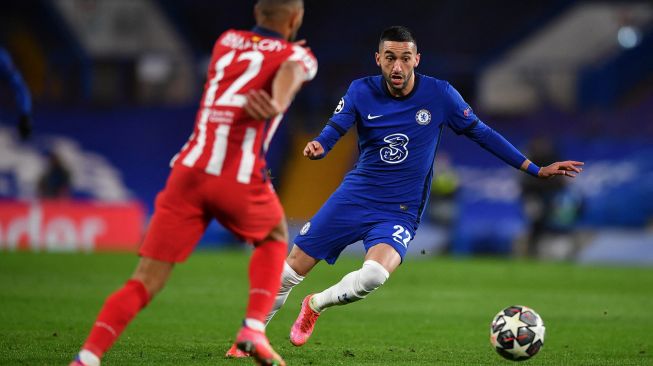 Gelandang Chelsea Hakim Ziyech bersaing dengan bek Atletico Madrid Renan Lodi selama selama pertandingan leg kedua babak 16 besar Liga Champions antara Chelsea melawan Atletico Madrid di Stamford Bridge, Kamis (18/3/2021) dini hari WIB. Ben STANSALL / AFP
