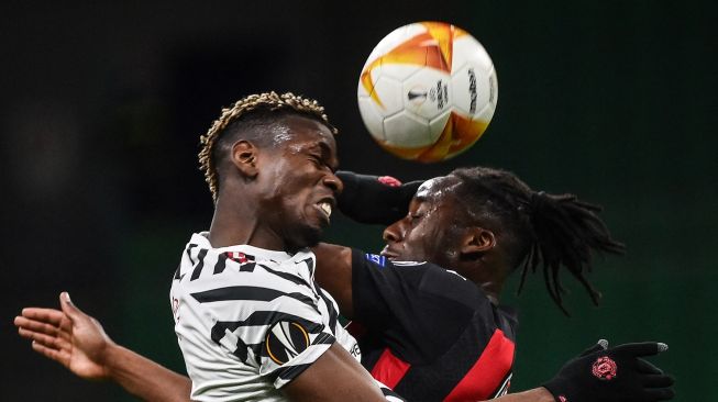 Gelandang Manchester United Paul Pogba (kiri) dan gelandang AC Milan Souhaliho Meite melakukan sundulan selama pertandingan sepak bola leg kedua babak 16 besar Liga Eropa UEFA antara AC Milan melawan Manchester United di stadion San Siro, Milan, Italia,  Jumat (19/3/2021) dini hari WIB. Marco BERTORELLO / AFP
