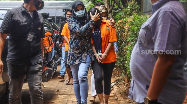 Artis Cynthiara Alona saat akan dibawa kembali ke dalam rutan usai rilis kasus prostitusi online di Polda Metro Jaya, Jakarta Selatan, Jumat, (19/3/2021). [Suara.com/Alfian Winanto]