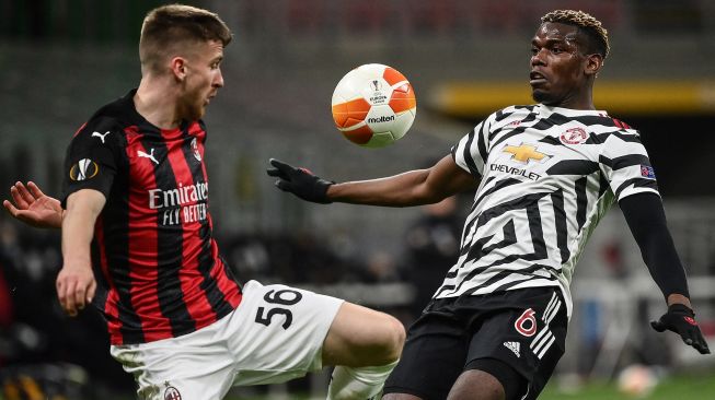 Penyerang AC Milan Alexis Saelemaekers (kiri) dan gelandang Manchester United Paul Pogba memperebutkan bola selama pertandingan sepak bola leg kedua babak 16 besar Liga Eropa UEFA antara AC Milan melawan Manchester United di stadion San Siro, Milan, Italia,  Jumat (19/3/2021) dini hari WIB. 
Marco BERTORELLO / AFP
