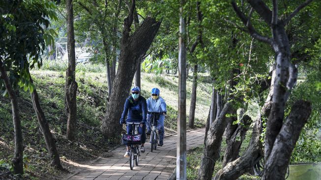 Sejumlah pengunjung bersepeda saat berkunjung ke ruang terbuka hijau (RTH) di Utan Kemayoran, Jakarta, Sabtu (20/3/2021). [ANTARA FOTO/M Risyal Hidayat]