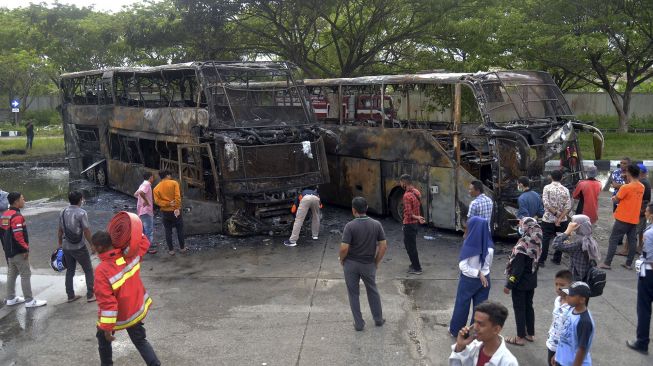 Tim Unit Identifikasi Polri memeriksa tempat kejadian perkara pascakebakaran dua unit bus umum antar provinsi di Terminal Batoh, Banda Aceh, Aceh, Sabtu (20/3/2021). [ANTARA FOTO/Ampelsa]