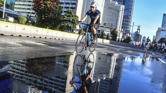 Warga bersepeda di kawasan Bundaran HI, Jakarta, Minggu (21/3/2021).  ANTARA FOTO/Muhammad Adimaja