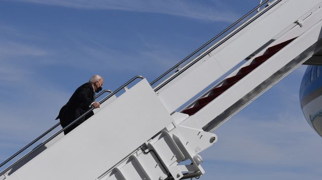 Presiden AS Joe Biden tersandung saat menaiki pesawat kepresidenan Air Force Ond di Pangkalan Gabungan Andrews, Maryland, 19 Maret 2021. ERIC BARADAT / AFP