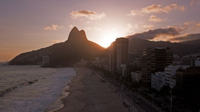 Pantai Ipanema yang kosong terlihat pada hari penutupan pantai Rio de Janeiro sebagai tindakan pembatasan untuk menahan wabah penyakit virus korona, COVID-19, di Rio de Janeiro, Brasil, pada 20 Maret 2021.  Florian PLAUCHEUR / AFP