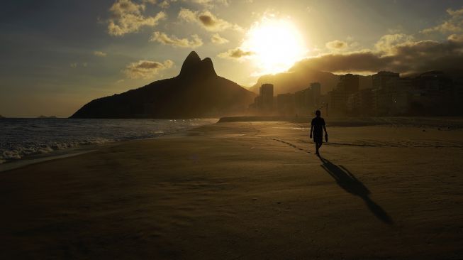 Pantai Ipanema yang kosong terlihat pada hari penutupan pantai Rio de Janeiro sebagai tindakan pembatasan untuk menahan wabah penyakit virus korona, COVID-19, di Rio de Janeiro, Brasil, pada 20 Maret 2021.  Florian PLAUCHEUR / AFP