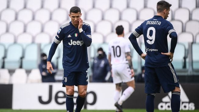 Penyerang Juventus Cristiano Ronaldo (tengah) dan penyerang Juventus Alvaro Morata (kiri) tertunduk setelah Benevento membuka skor selama pertandingan sepak bola Serie A Italia Juventus melawan Benevento di Juventus Stadium, Turin, Minggu (21/3/2021) malam WIB.  Marco BERTORELLO / AFP