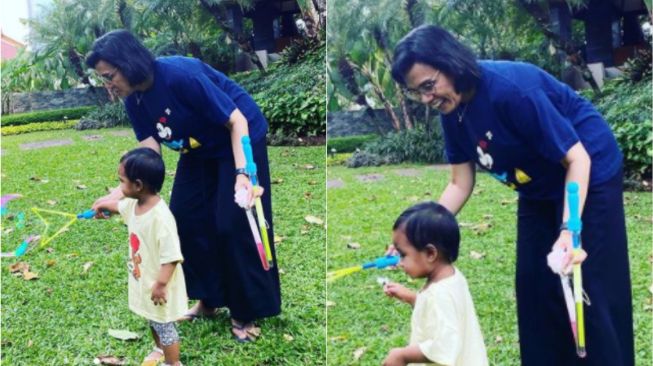 Gaya Santai Sri Mulyani Pakai Kaus Oblong dan Sandal Jepit saat Momong Cucu