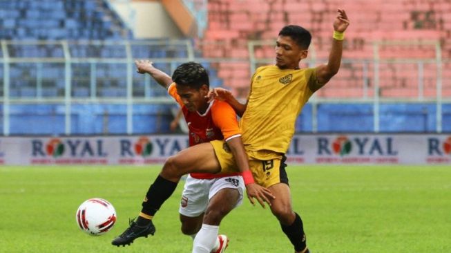 Pesepakbola Bhayangkara Solo FC, M Ichsan (kanan) berusaha merebut bola dari pesepakbola Borneo FC Samarinda, Mohammad Mifathul Ichsan (kiri) dalam pertandingan babak penyisihan Grup B Piala Menpora di Stadion Kanjuruhan, Malang, Jawa Timur, Senin (22/3/2021). Bhayangkara Solo FC mengalahkan Borneo FC Samarinda dengan skor akhir 1-0. )ANTARA FOTO/Ari Bowo Sucipto).