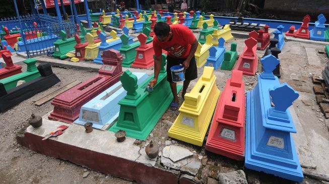 Seorang warga mengecat batu nisan di tempat pemakaman Gedhong Sasono Palereman, Jetis, Bakungan, Karangdowo, Klaten, Jawa Tengah, Senin (22/3/2021).  ANTARA FOTO/Aloysius Jarot Nugroho