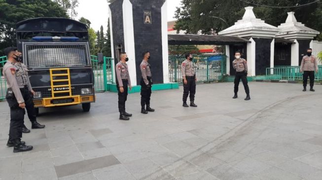 Polisi berjaga di depan Pintu Masuk A Stadion Manahan Solo atau dekat Plaza Manahan saat berlangsungnya laga sepak bola Piala Menpora 2021, Minggu (21/3/2021) sore. (Solopos/Kurniawan)