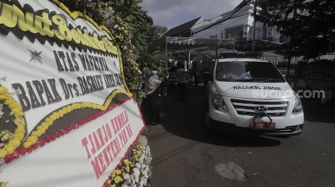 Mobil ambulans yang membawa jenazah Mantan Jaksa Agung Basrief Arief bersiap meninggalkan rumah duka di kawasan Petogogan, Kebayoran Baru, Jakarta, Selasa (23/3/2021). [Suara.com/Angga Budhiyanto]