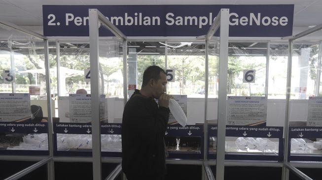 Calon penumpang meniup kantong nafas saat mengikuti tes deteksi COVID-19 dengan metode Gajah Mada Electric Nose COVID-19 (GeNose C19) di Stasiun Gambir, Jakarta, Rabu (24/3/2021). [Suara.com/Angga Budhiyanto]