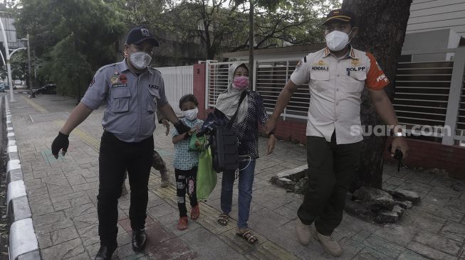 Petugas Suku Dinas Sosial dan Satpol PP Jakarta Selatan membawa warga yang terjaring razia Penyandang Masalah Kesejahteraan Sosial (PMKS) di kawasan Bulungan, Jakarta , Rabu (24/3/2021). [Suara.com/Angga Budhiyanto]