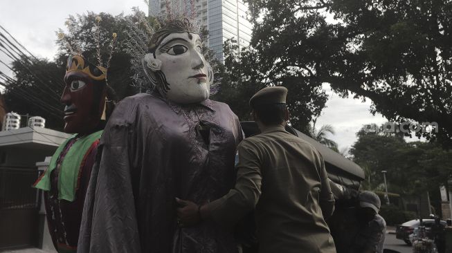 Petugas Suku Dinas Sosial dan Satpol PP Jakarta Selatan membawa ondel-ondel yang terjaring razia Penyandang Masalah Kesejahteraan Sosial (PMKS) di kawasan Bulungan, Jakarta , Rabu (24/3/2021). [Suara.com/Angga Budhiyanto]